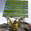 Spencer West at the summit of Mount Kilimanjaro