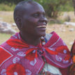 Me to We Artisans beading under an acacia tree.